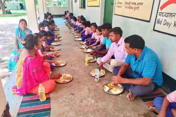 मुखिया और उप मुखिया  विद्यार्थियों के साथ जमीन पर बैठ कर मध्याह्न भोजन करते हुए.