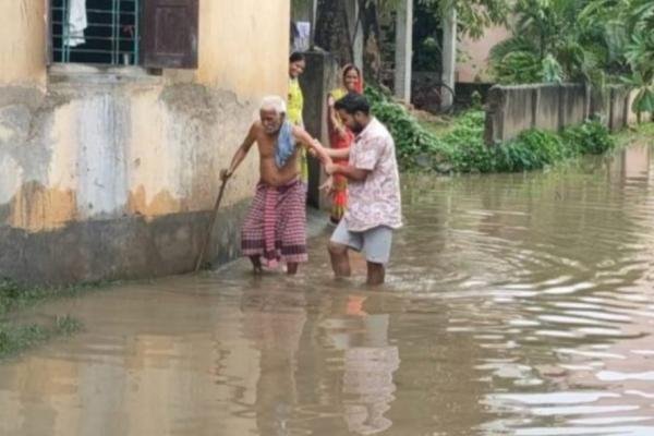 सड़क पर जल जमाव के बीच आना-जाना करते लोग.