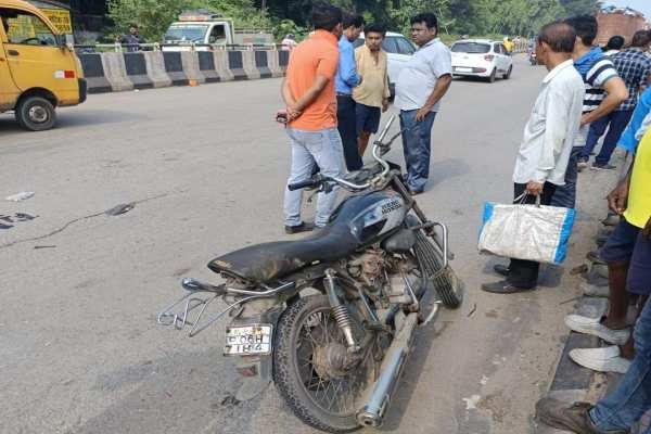 घटनास्थल पर खड़े लोग और दुर्घटनाग्रस्त बाइक.