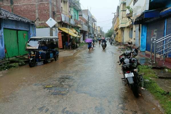 चक्रधरपुर में बारिश के बीच आवजाही करते लोग.