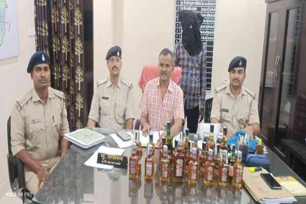 जब्त शराब के साथ पुलिस अधिकारी  