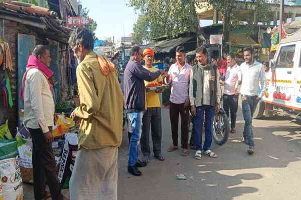 मिठाई बांटते कार्यकर्ता